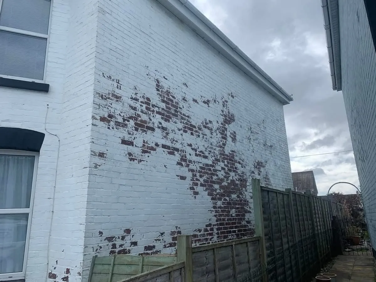 Peeling paint on a brick wall before redecoration in Mevagissey
